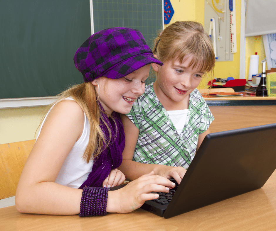 Photo of two primary school girls studying coding in a classroom.