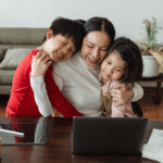 Photo of happy mother with 2 kids studying online course.