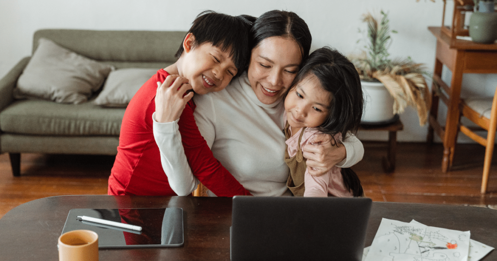Photo of happy mother with 2 kids studying online course.