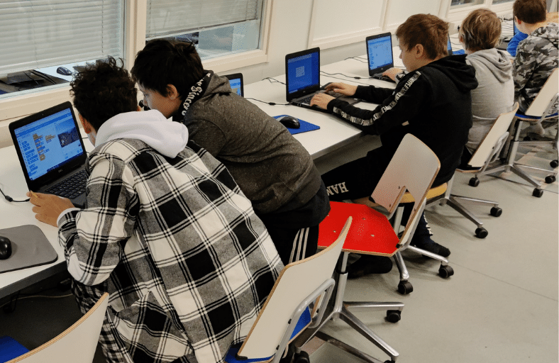 Students working with their computers in a classroom at Rajakylä School.